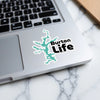 Turquoise lake outline sticker with black "Burton Life" text on a laptop.