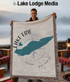 Man holds a woven blanket featuring Lake Erie map design and compass rose.