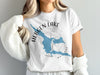 White t-shirt with blue Hebgen Lake shape, compass rose, and text.