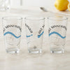 Three clear glasses with "Lake Minnewanka" and compass graphic.