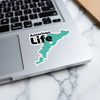 Sticker with "American Life" text and teal outline on laptop.