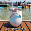 A white insulated tumbler with Merrymeeting Lake New Hampshire graphic stands on a wooden boat deck.