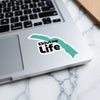 Eklutna Life sticker on a laptop with teal lake graphic