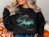 Black sweatshirt with "Lake Ouachita Arkansas" and compass graphic.