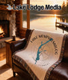 Woven blanket with Lake Memphremagog Vermont compass design on leather couch.