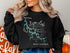 Black crewneck sweatshirt featuring a compass rose and a map outline of East Lynn Lake, West Virginia.