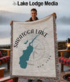 A man holds a Saratoga Lake New York map throw blanket with a compass rose design.