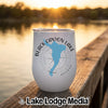 White stainless steel wine tumbler featuring a blue map of Black Canyon Lake and a compass design sitting on a wooden dock at sunset.