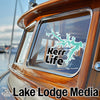 Teal Kerr Lake outline sticker and "Lake Lodge Media" text on wood boat window.