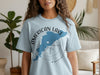 Light blue t-shirt with American Lake Washington map and compass graphic.