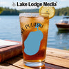 Glass of iced tea with lemon on a table next to a book, with "Lake Lodge Media" logo.
