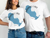 White t-shirts featuring a blue outline of Sandhill Lake and compass graphics, with text "Sandhill Lake Wisconsin".