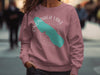 Rose crewneck sweatshirt with teal "Onondaga Lake" graphic and compass rose.