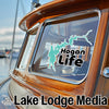 Turquoise map outline sticker labeled "Hogan Life" on a boat window.