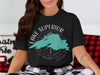 Black t-shirt with a teal map of Lake Superior and a compass graphic.