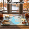 A rectangular glass cutting board featuring a blue map of Lake Tohopekaliga, Florida, rests on a wooden table with crackers, cheese, and pecans.
