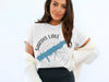 White t-shirt with a blue Sardis Lake outline and compass graphic.