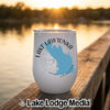 A white stemless wine tumbler featuring a blue map of Lake Lawtonka sits on a wooden dock at sunset.