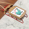 Wooden sled ornament with "Merry Christmas FROM Rose Canyon" text and snowflakes.