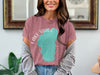 Pink t-shirt with a teal Lake Tahoe shape and compass graphic.