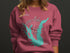 Pink sweatshirt with "Calaveras Lake Texas" and compass rose graphic.