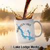 White mug with Walloon Lake map and compass, coffee pouring splash.
