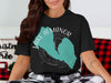 Black t-shirt featuring Lake Almanor, California, stylized map with compass design.