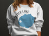 White crewneck sweatshirt with Crater Lake Oregon map and compass design.
