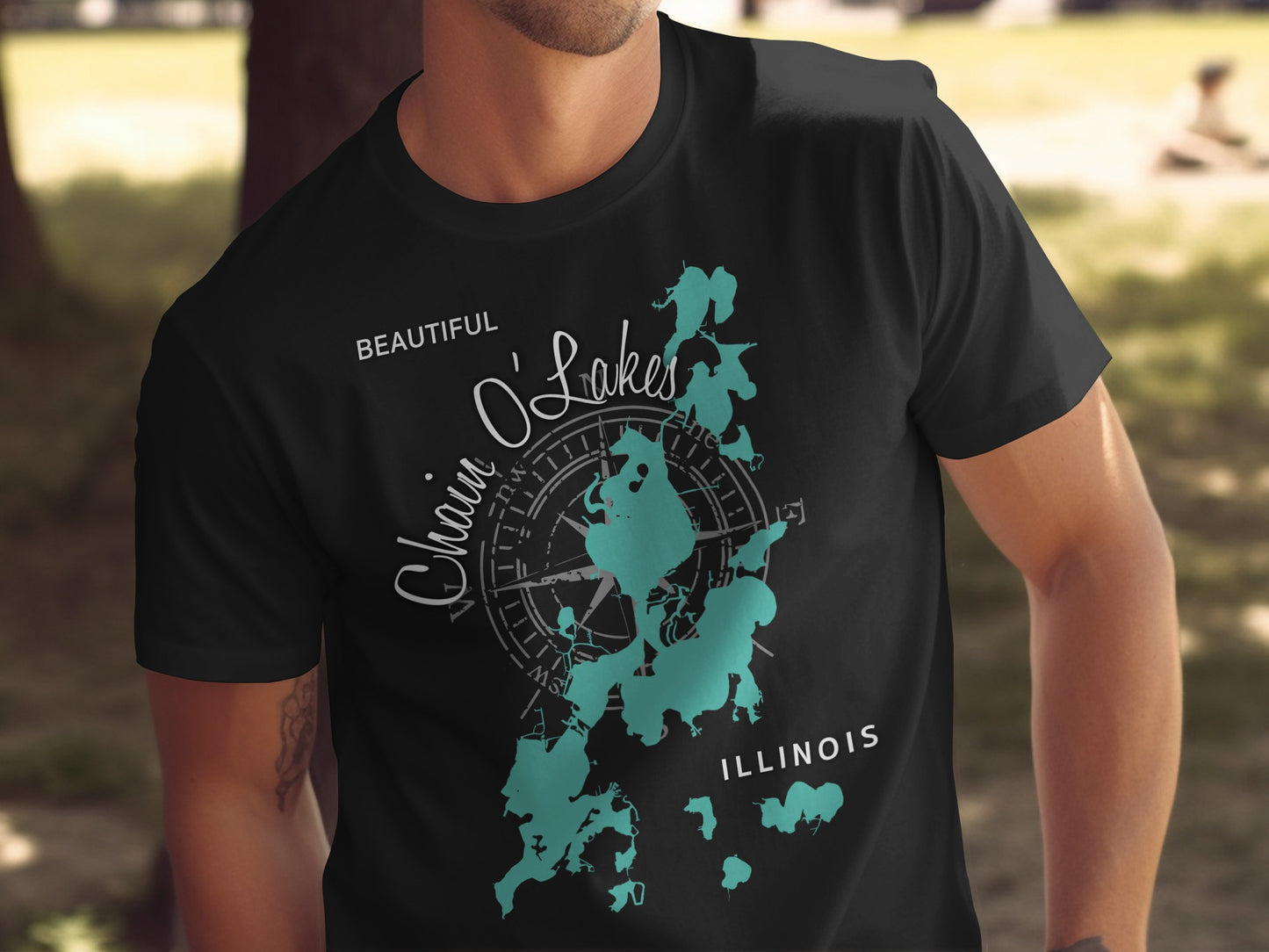 Black t-shirt with teal map of Chain O'Lakes Illinois and compass.
