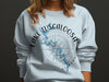 Light blue sweatshirt with Lake Tuscaloosa map and compass graphic.
