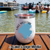 A white insulated wine tumbler featuring a Lake Moultrie, South Carolina map design on a wooden surface with people in the lake background.