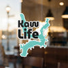 Teal "Kaw Life" text and lake outline sticker on a window.