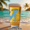Glass of beer with "Lake Dillon" and Colorado outline on a beach.
