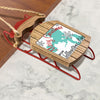 Wooden ornament on red sled with map and text "Merry Christmas From Yellowstone Lake".