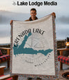 Man holding Grenada Lake Mississippi map blanket with compass rose design.