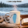 White mug with "Black Lake Idaho" map design, steaming hot, by a rainy window.