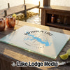 A rectangular glass cutting board featuring a Rathbun Lake map design on a wooden outdoor bar.
