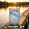 A white insulated wine tumbler featuring a blue outline of Lake Wenatchee and a compass rose design rests on a wooden dock at sunset.