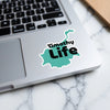 Teal shape sticker with "Timothy Life" text on a laptop.