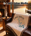 Throw blanket with Lake Travis Texas compass design on leather couch.