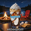 Dessert with whipped cream and caramel on a table by a campfire and lake.