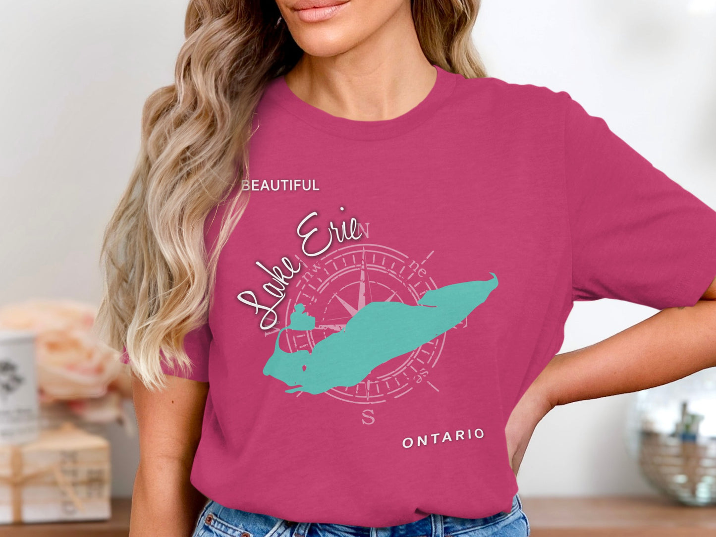 Teal Lake Erie map graphic with compass rose and text on a pink t-shirt.