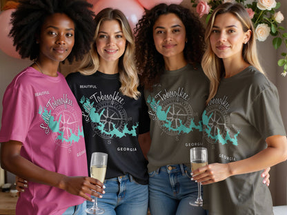 Four women in "Beautiful Lake Tobesofkee, Georgia" t-shirts hold champagne glasses.