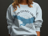 Light blue sweatshirt with Harlan County Lake, Nebraska map and compass graphic.