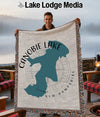 Man holding Canobie Lake, New Hampshire woven blanket with fringed edges.