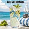 Glass with drink, limes, mint, and "Evergreen Lake Illinois" logo on beach background.