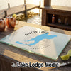 A rectangular glass cutting board featuring a blue Snow Lake, Washington map design sits on a wooden outdoor bar.