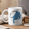 White mug with blue Lake Simcoe map and compass design, steam rising.