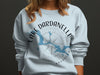 Light blue sweatshirt with Lake Dardanelle Arkansas map and compass graphic.