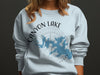 Light blue sweatshirt with Canyon Lake Texas map and compass design.